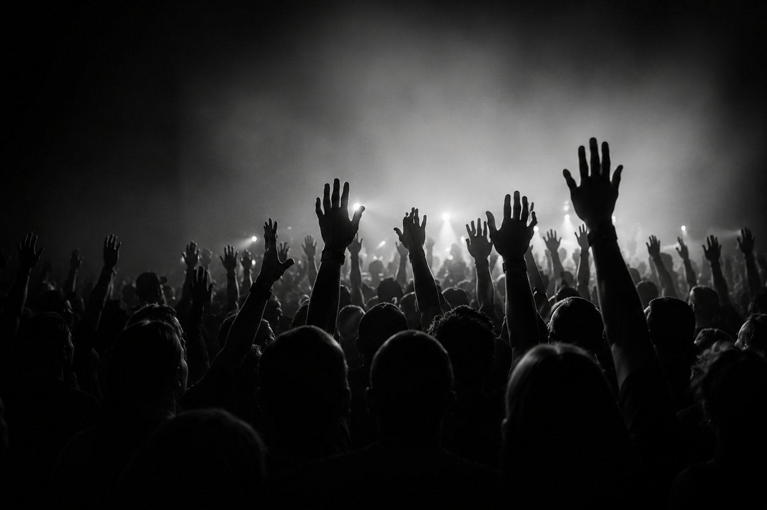 Audience gathered with hands raised during a live experience