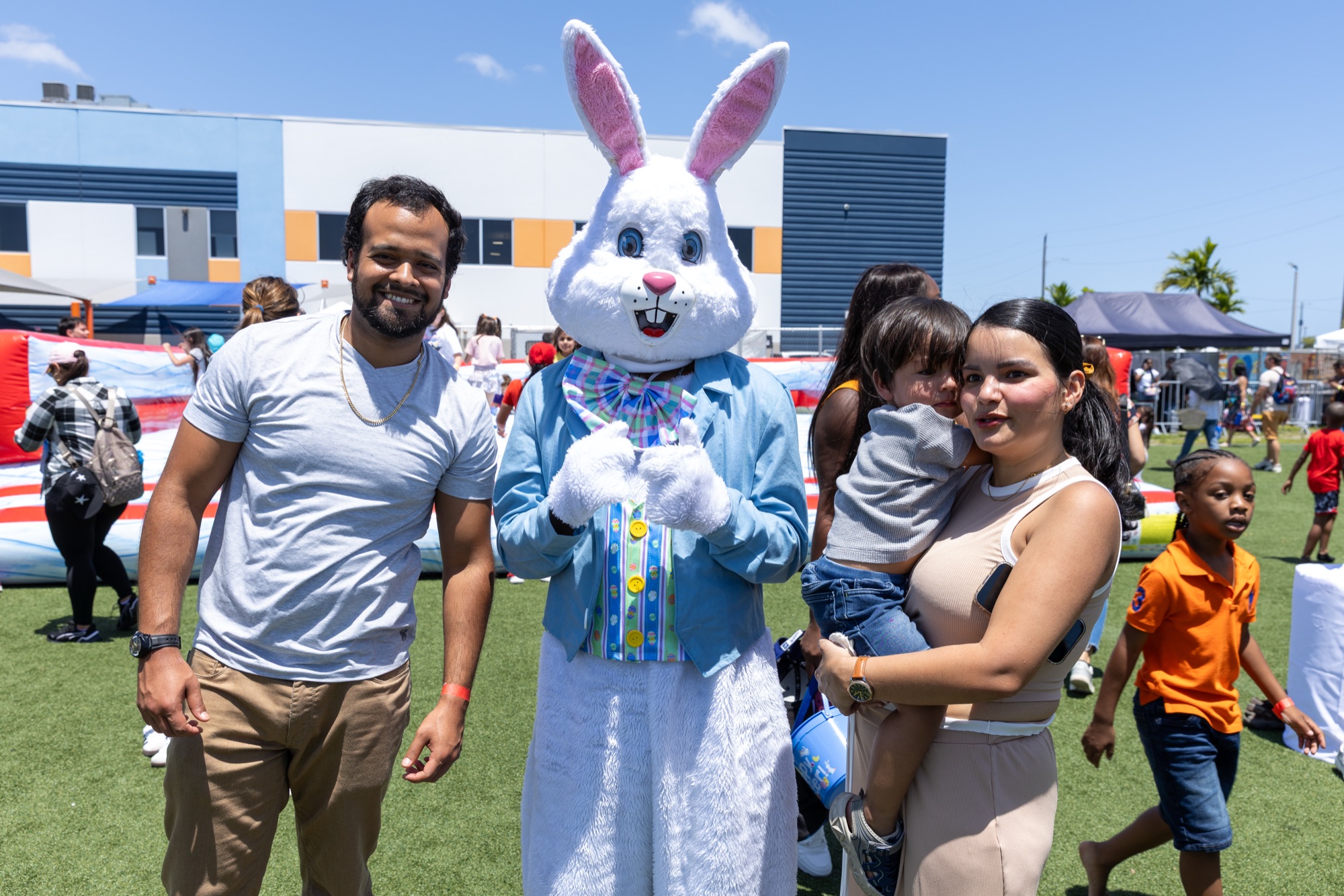 Family posing with Easter mascot at a community event